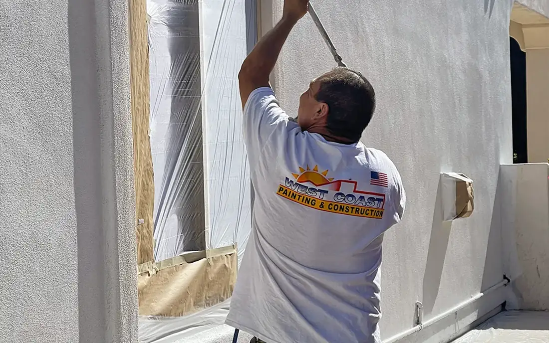 A West Coast painter spraying a stucco exterior